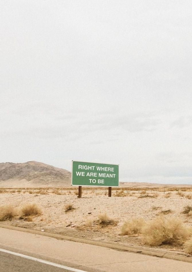 A desert highway beside pale mountain ridges