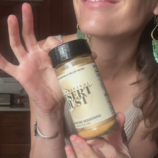 A person holding a Desert Dust seasoning bottle
