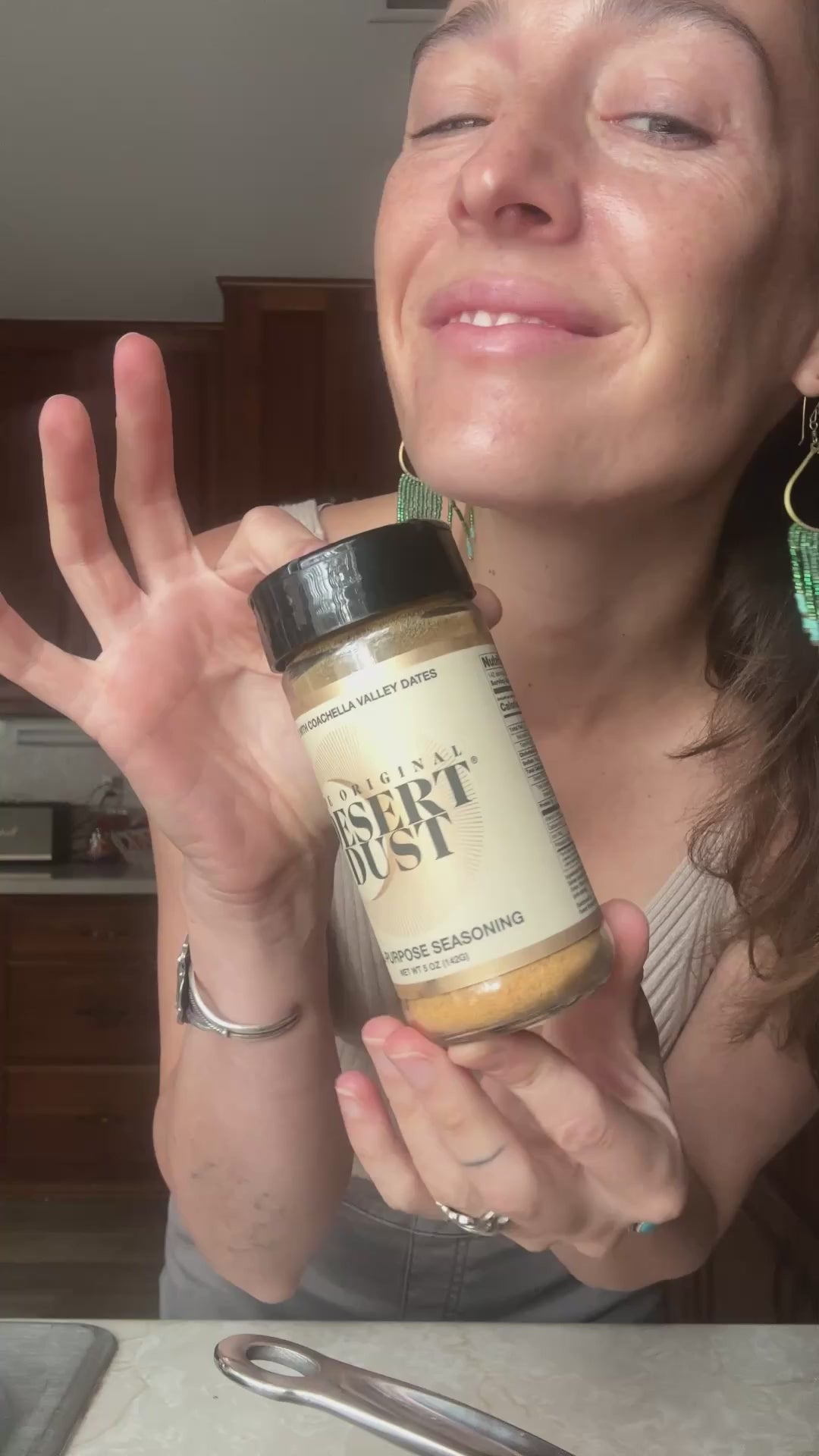 A person holding a Desert Dust seasoning bottle