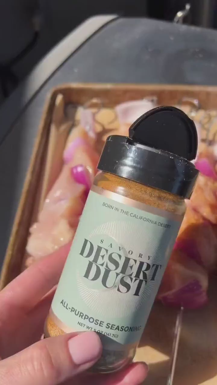 A Desert Dust seasoning bottle held beside a tray of food