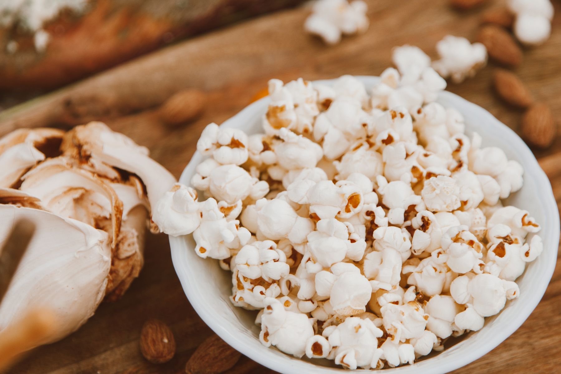 A bowl of freshly popped popcorn on a wooden table